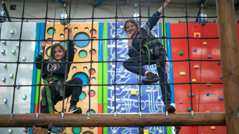 Two girls rock climbing in birthday party